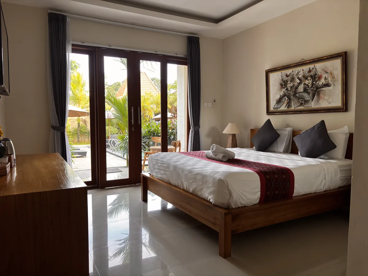 Bedroom with Balinese art and garden view at Londo House